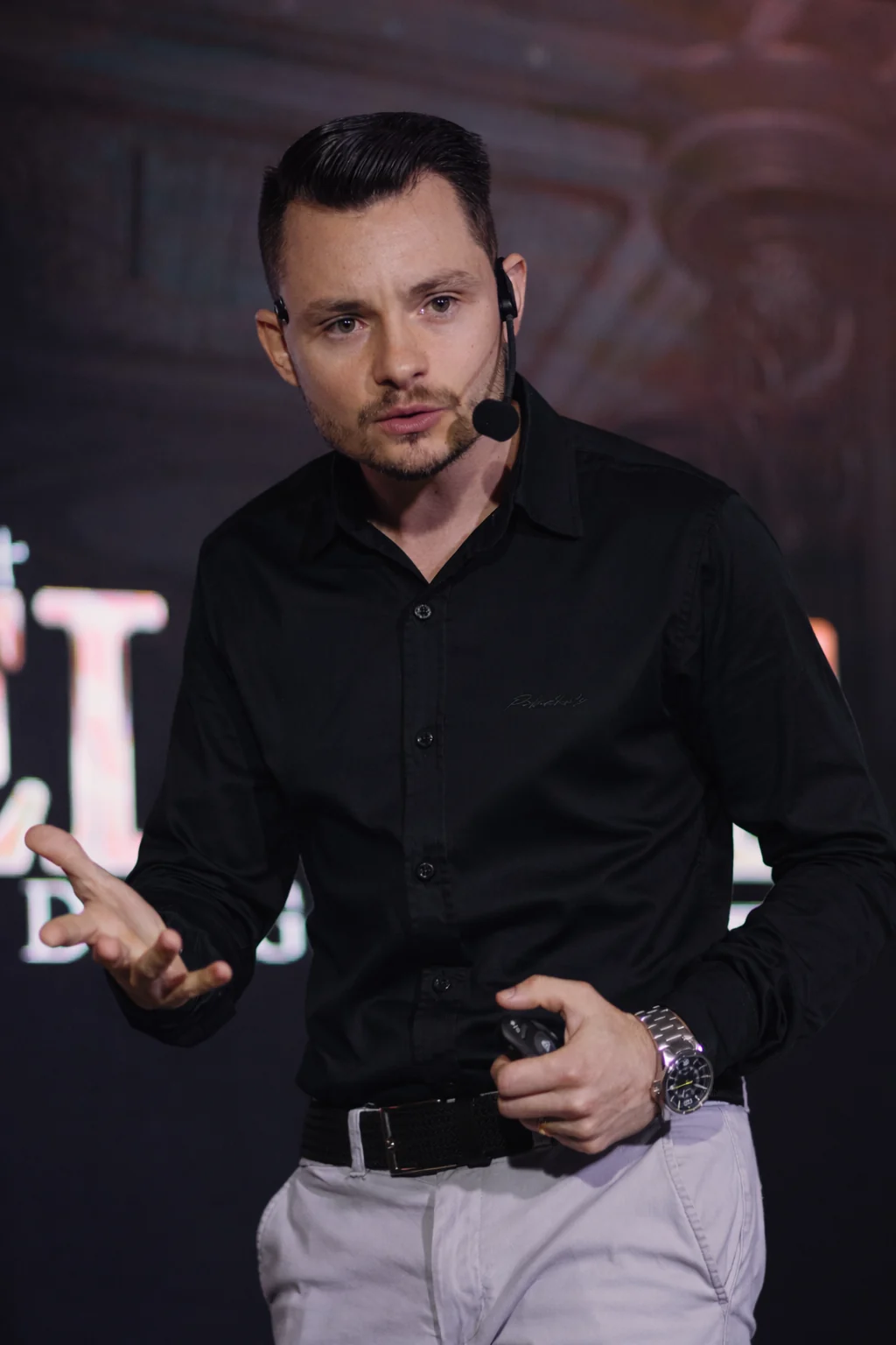 Felipe Bandezan no palco, com microfone, durante uma palestra
